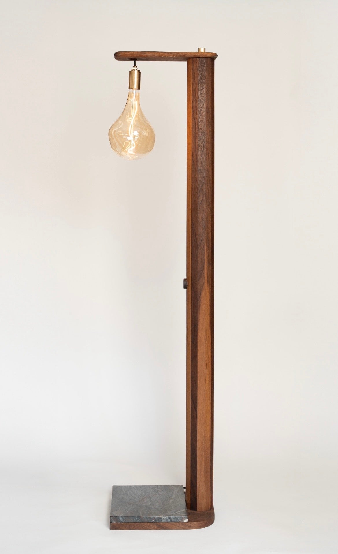 Handmade iN-v1 Walnut and Stone Floor Lamp by Redline Design, with a tall walnut post, hanging amber glass bulb, and a stone base