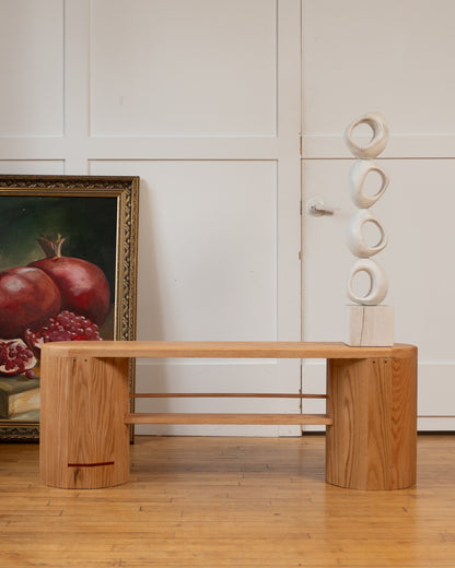 iB-v2 Dual Column Bench in red oak with its signature red line, styled with a pomegranate painting and stacked sculpture